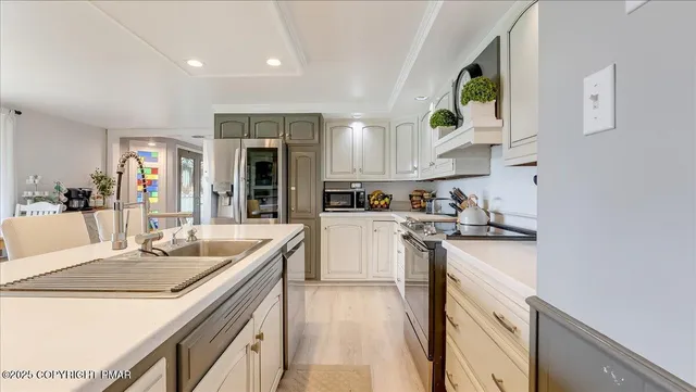 a kitchen with granite countertop kitchen island stainless steel appliances a sink a stove and a refrigerator