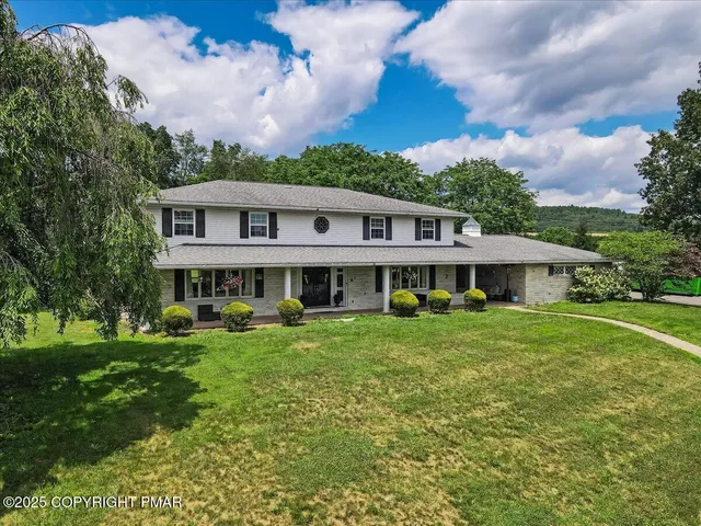 a view of a house with backyard sitting area and garden