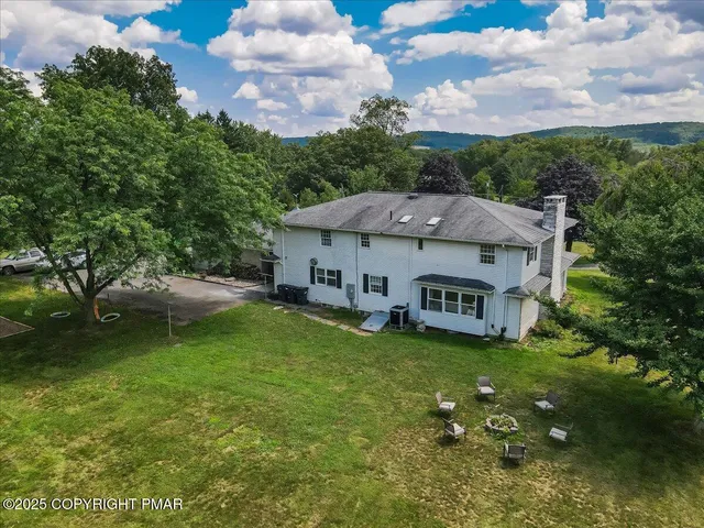 an aerial view of a houses with a swimming pool