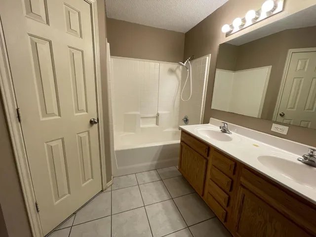 a bathroom with a double vanity sink a mirror and a bathtub