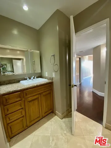 a spacious bathroom with a granite countertop sink and a mirror