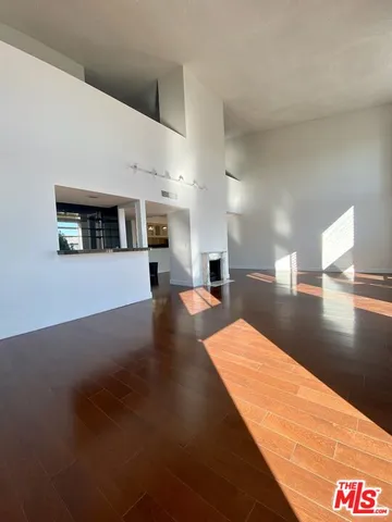 a view of empty room with wooden floor and floor to ceiling window