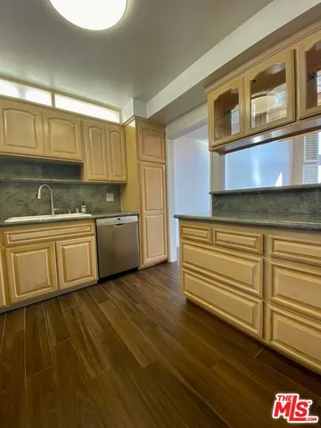 a view of a living room a kitchen with furniture and wooden floor