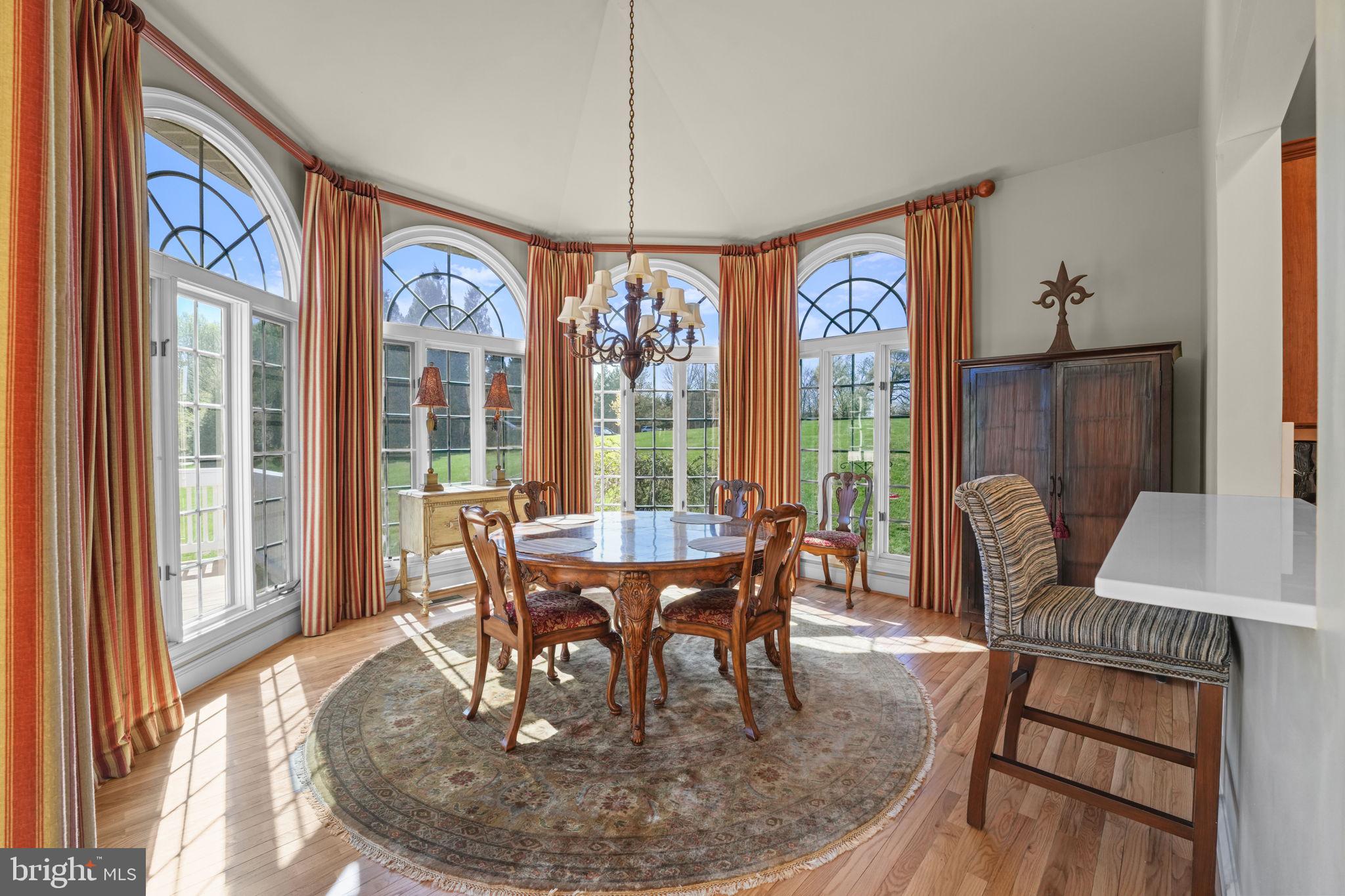 11431 Woolington Road Great Falls, VA 22066 - Photo 13 of 49 a dining room with furniture a chandelier and wooden floor