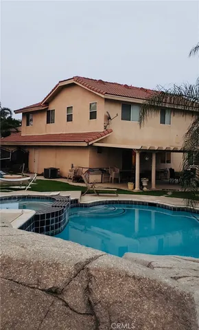 a view of a house with swimming pool and a yard