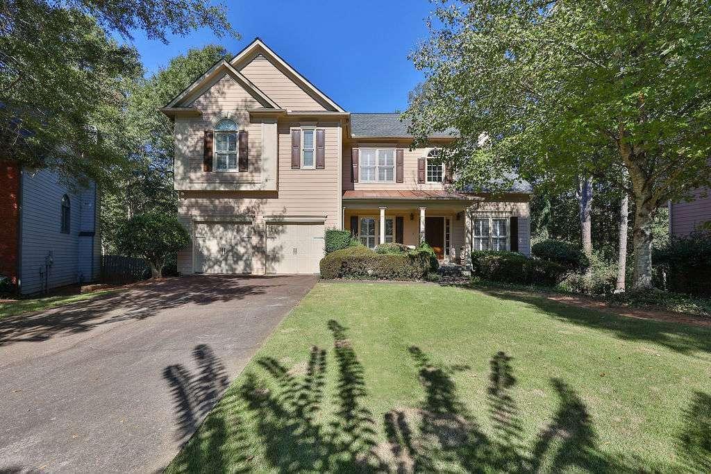 a front view of a house with yard and green space