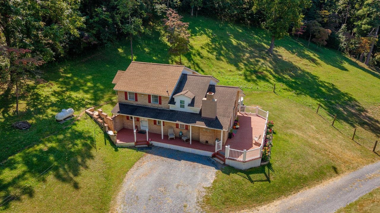279 Helms Road Stanley, VA 22851 - Photo 56 of 64 an aerial view of a house with swimming pool and trees
