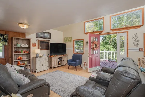 a living room with furniture a flat screen tv and a large window