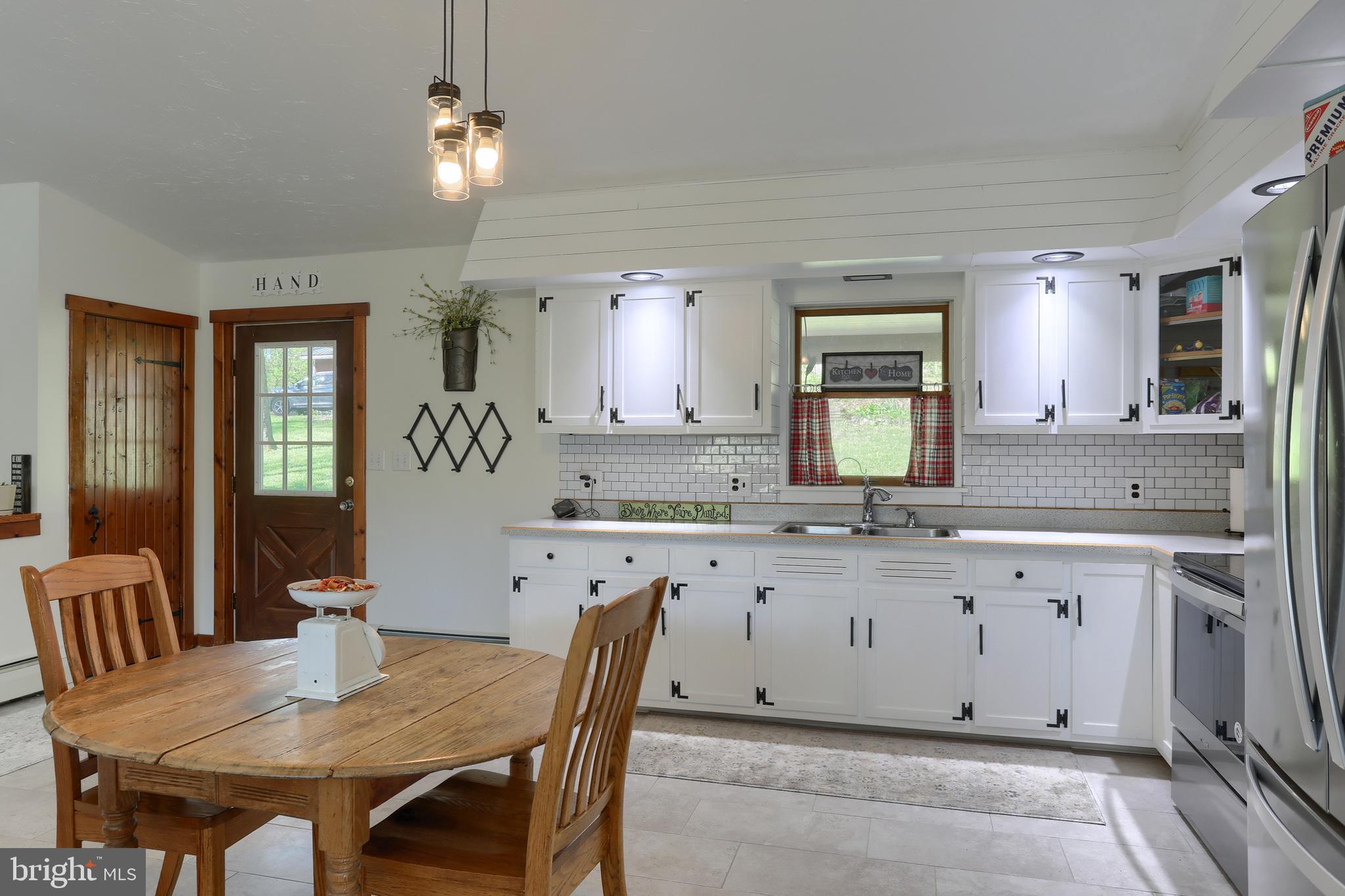 10 Bullfrog Road Grantville, PA 17028 - Photo 11 of 51 a large kitchen with granite countertop a dining table chairs and white cabinets