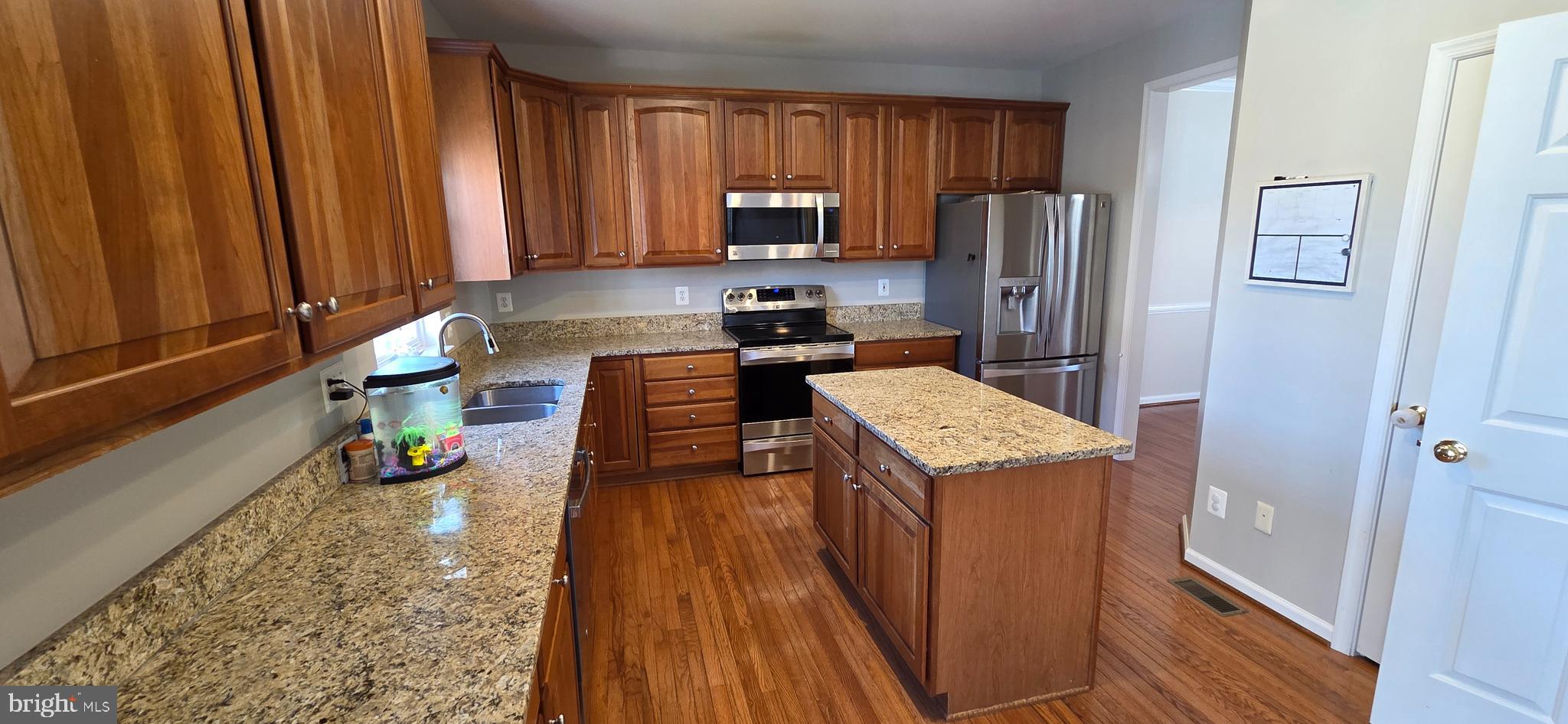 25366 Vacation Place Aldie, VA 20105 - Photo 3 of 51 a kitchen with a refrigerator a stove and wooden floor