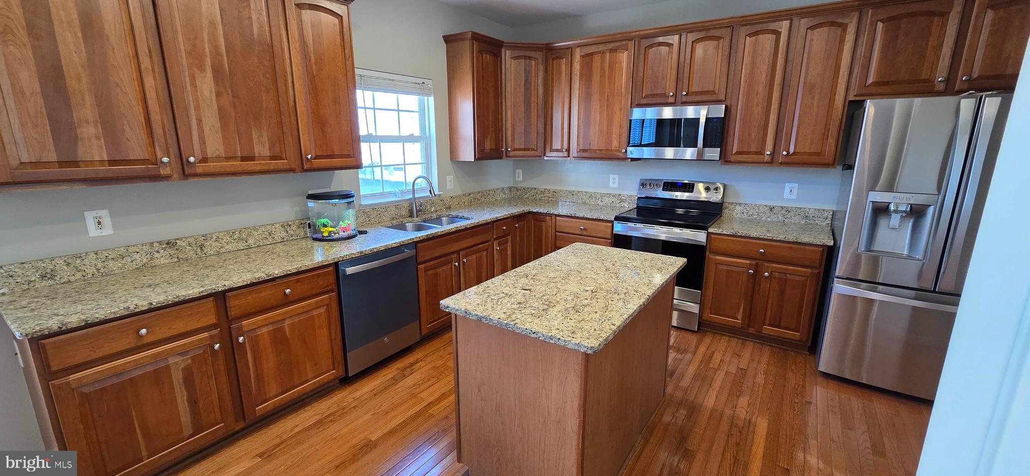 25366 Vacation Place Aldie, VA 20105 - Photo 4 of 51 a kitchen with stainless steel appliances granite countertop wooden cabinets a refrigerator and a sink