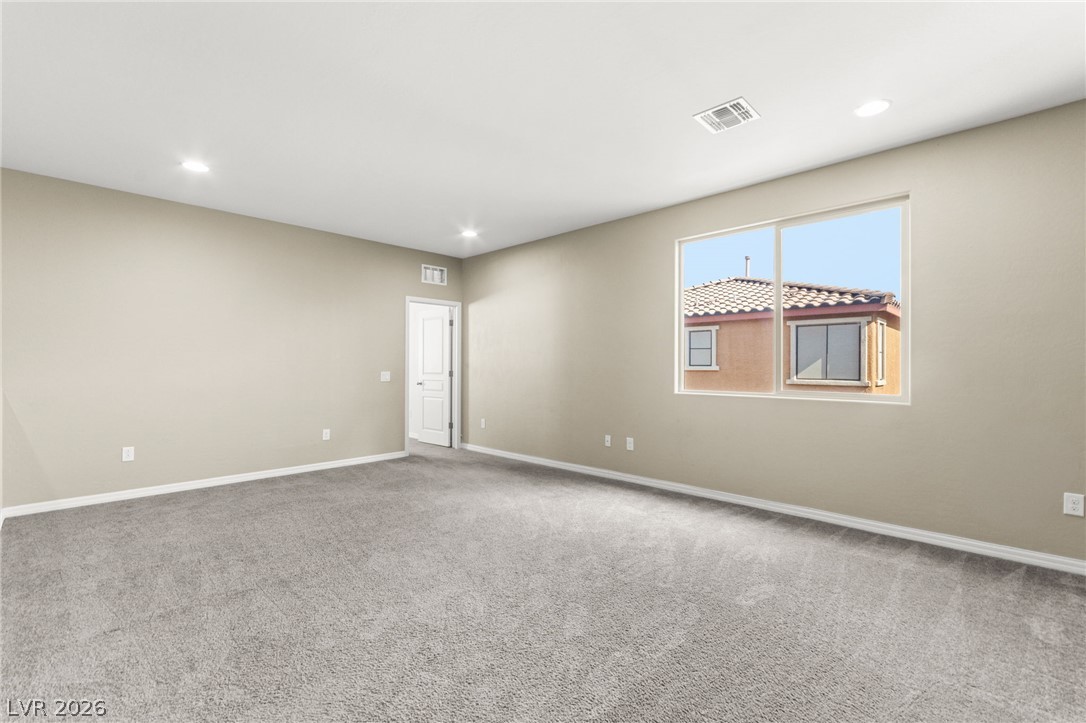 11048 Prairie Grove Road Las Vegas, NV 89179 - Photo 39 of 75 A spacious, neutral-toned room offers plush carpeting and ample natural light.