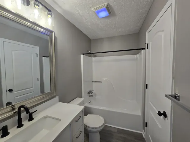 a bathroom with a sink a toilet and a large mirror