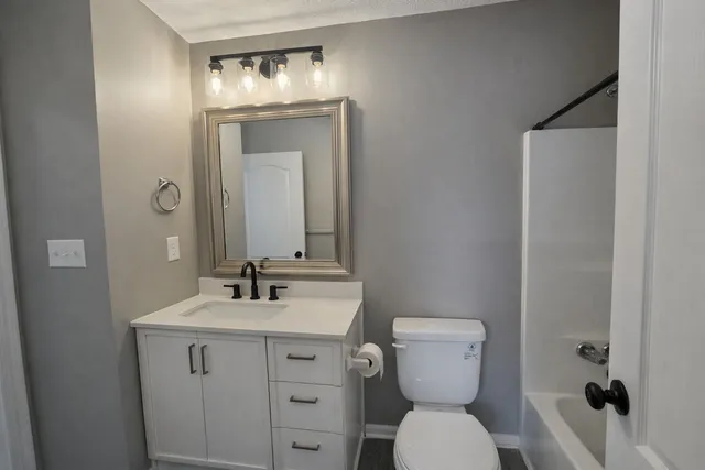 a bathroom with a toilet sink and mirror