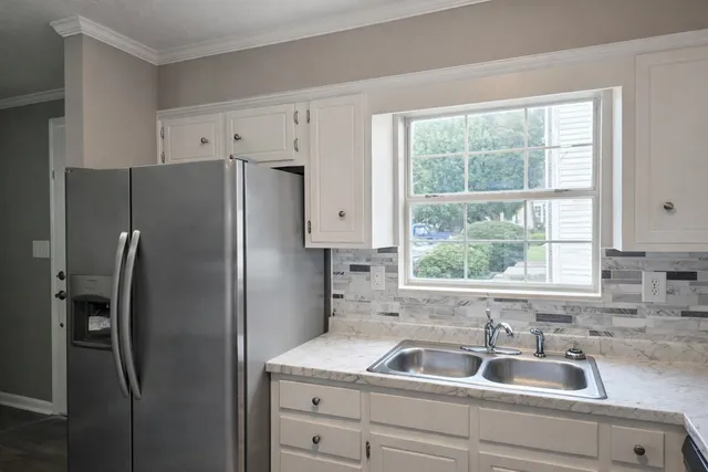 a kitchen with a refrigerator sink and mirror