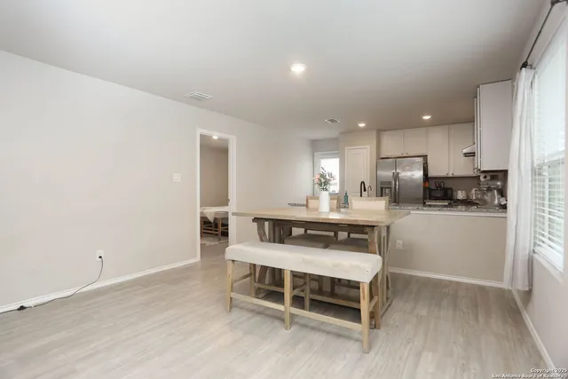 a kitchen with a refrigerator and white cabinets