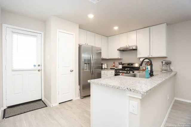 a kitchen with a refrigerator a sink and cabinets