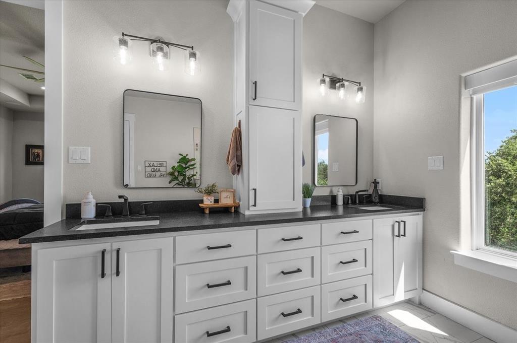 1059 Sweeney Way Weatherford, TX 76087 - Photo 15 of 37 Dual vanity with white cabinetry, black hardware, granite countertops, hidden plugs in the drawers and cabinets and a natural light