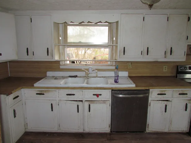 a kitchen with cabinets appliances and a window