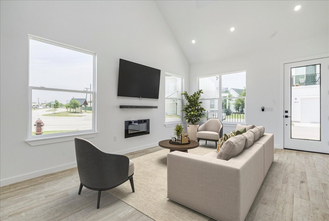 126 Lourdes Court, Unit B Dripping Springs, TX 78620 - Photo 6 of 19 a living room with furniture a fireplace and a flat screen tv