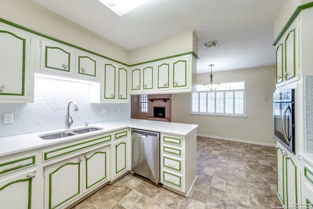 a kitchen that has a sink a stove and cabinets