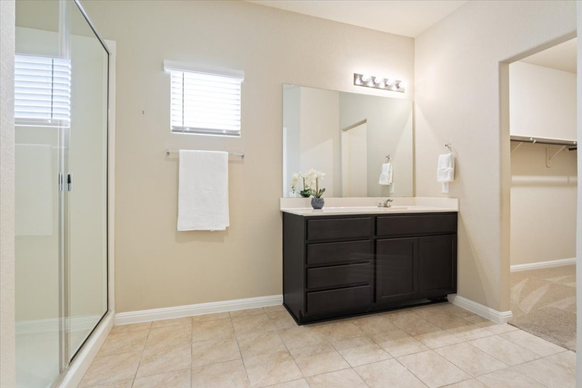 1504 Maier Drive Pflugerville, TX 78660 - Photo 13 of 31 a bathroom with a vanity a sink a mirror and a bathtub