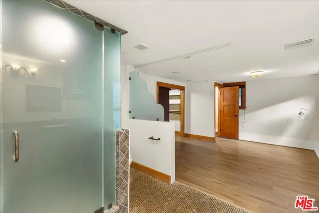 a view of a hallway with wooden floor and front door