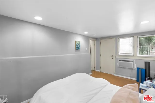 a bedroom with a bed and a window with chair