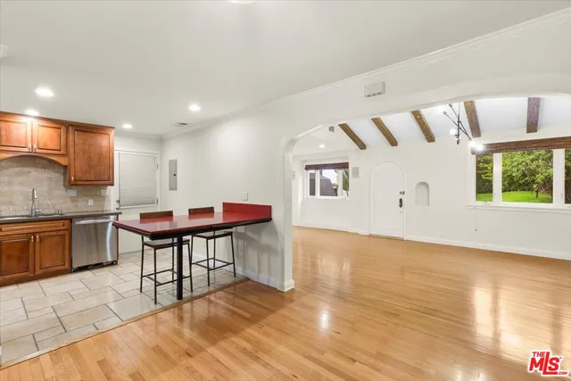 a living room with a table chairs and kitchen view