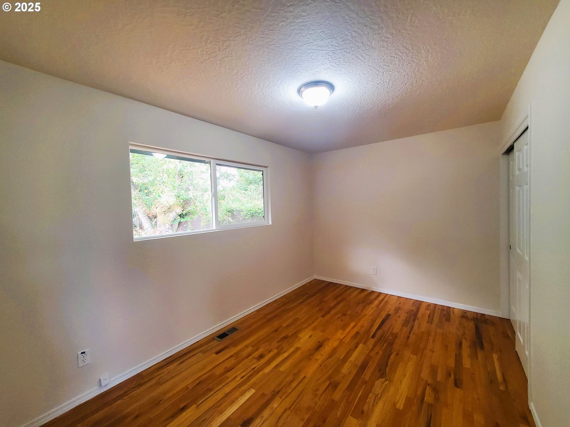 13050 Southeast Morrison Street Portland, OR 97233 - Photo 13 of 21 an empty room with wooden floor and windows
