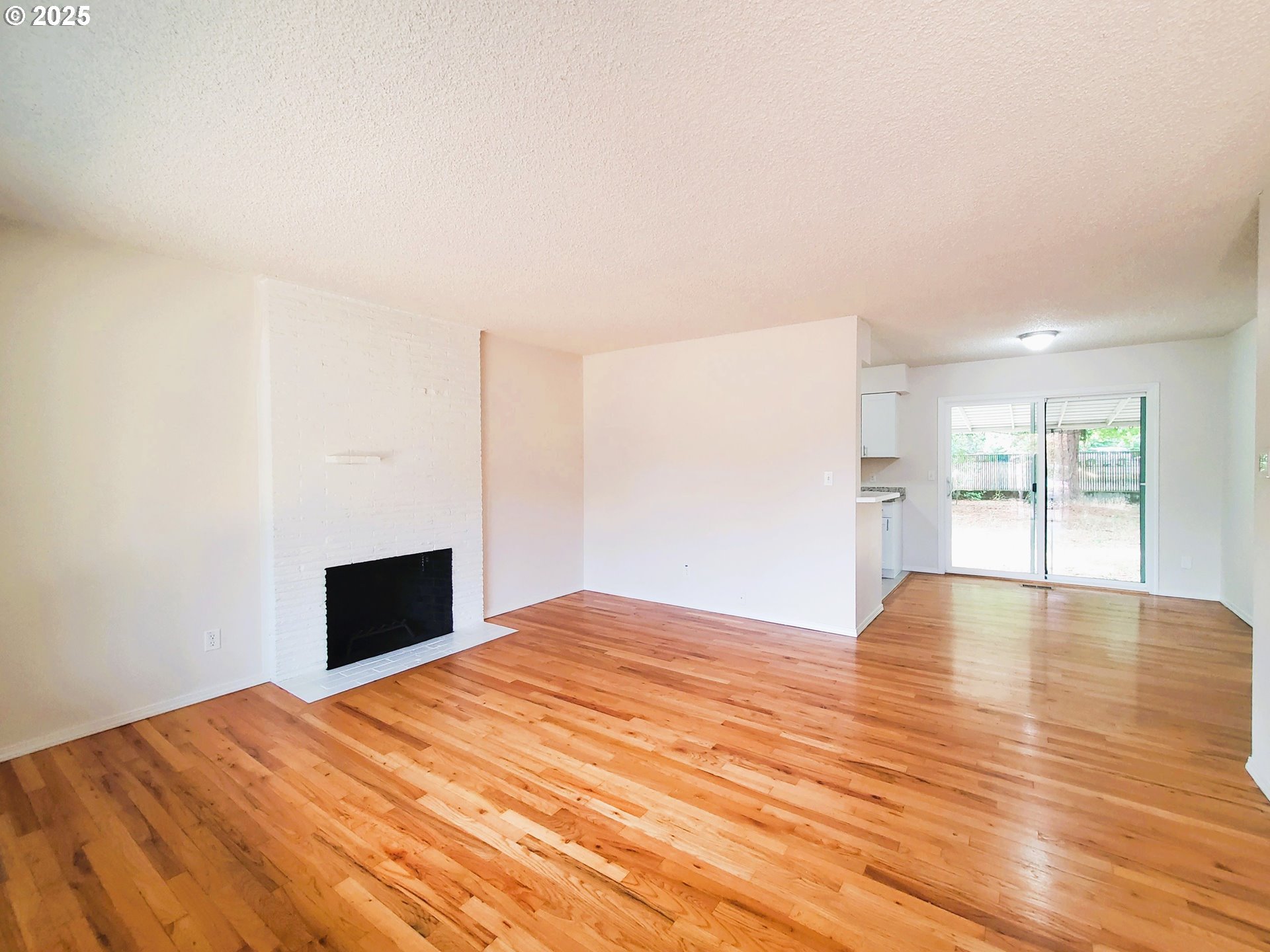 13050 Southeast Morrison Street Portland, OR 97233 - Photo 4 of 21 a view of empty room with wooden floor and fireplace
