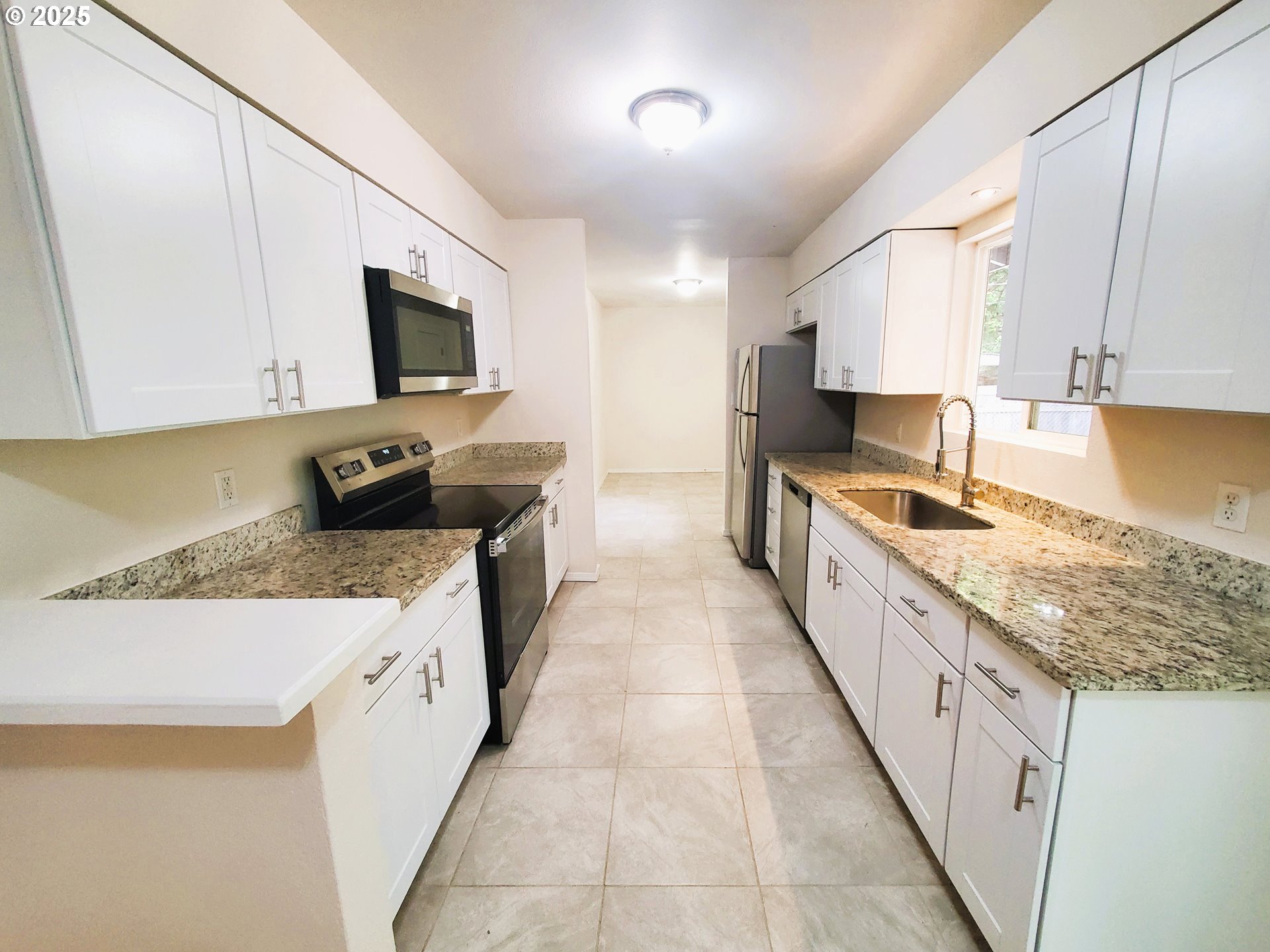 13050 Southeast Morrison Street Portland, OR 97233 - Photo 5 of 21 a kitchen with granite countertop a sink a stove top oven a counter space and cabinets