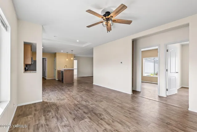 a view of a livingroom with a ceiling fan wooden floor and window