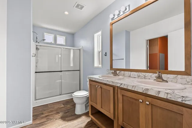 a bathroom with a granite countertop sink toilet and shower
