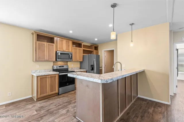 a kitchen with stainless steel appliances granite countertop a sink a stove and a refrigerator