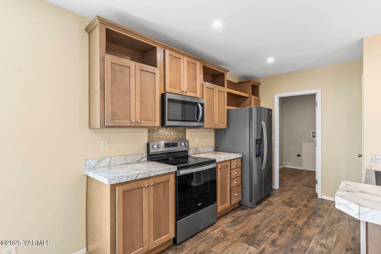 2802 South 5th Avenue, Unit 30 Union Gap, WA 98903 - Photo 9 of 23 a kitchen with stainless steel appliances granite countertop a stove a sink and a refrigerator with wooden floor
