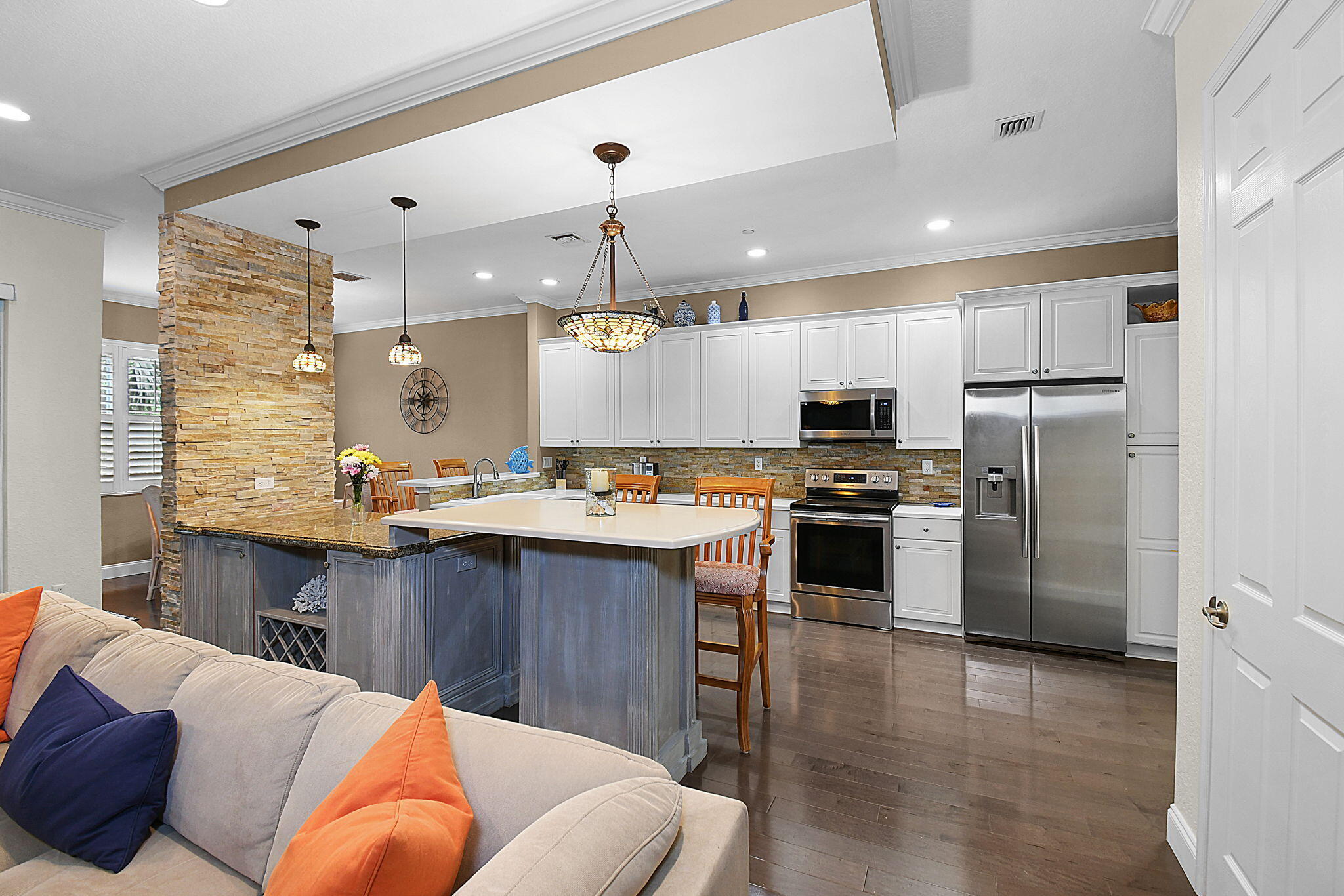 254 Southwest Walking Path Stuart, FL 34997 - Photo 6 of 31 a kitchen with stainless steel appliances kitchen island granite countertop a refrigerator a stove a sink dishwasher and a dining table with wooden floor