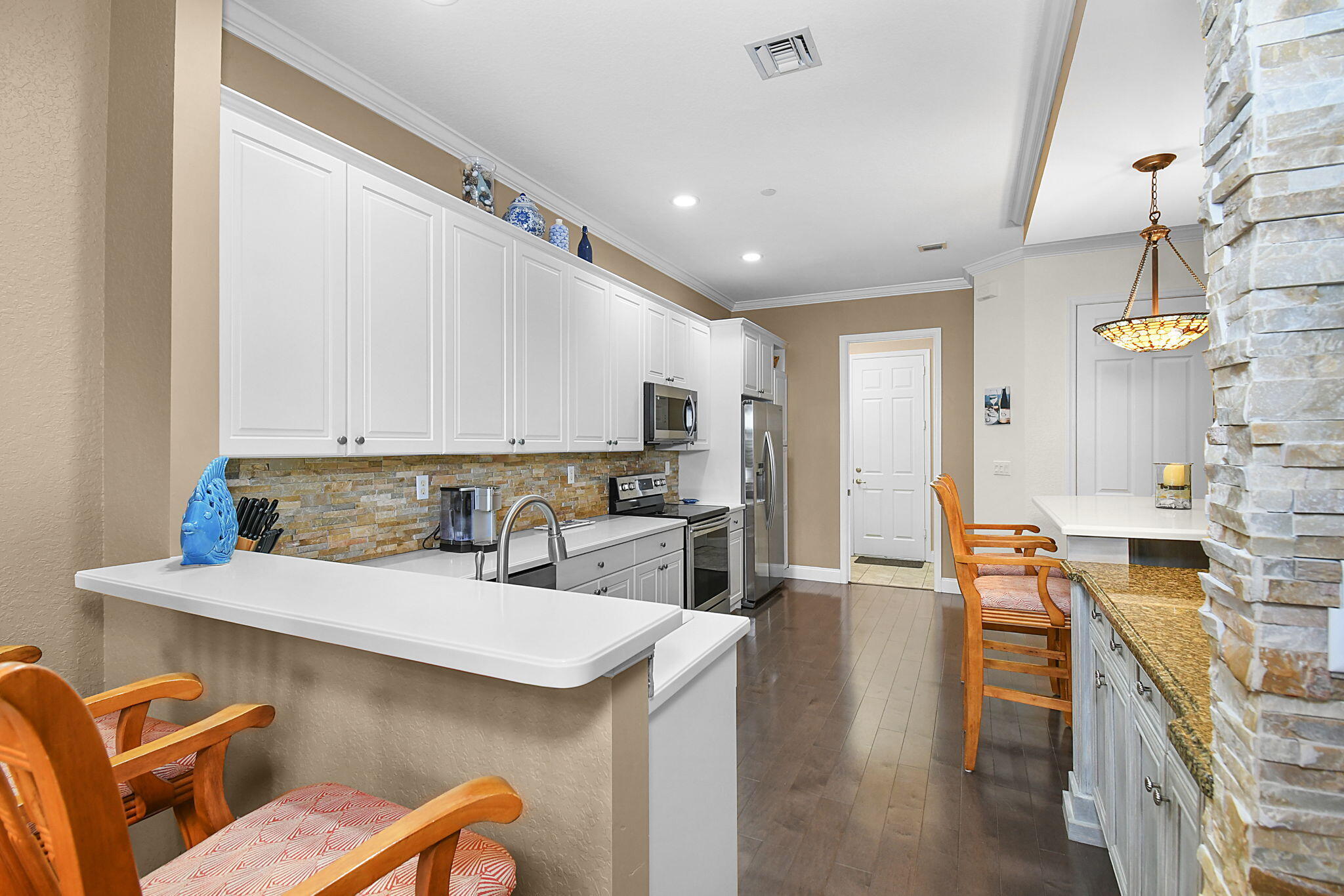 254 Southwest Walking Path Stuart, FL 34997 - Photo 9 of 31 a kitchen with stainless steel appliances kitchen island granite countertop a sink and cabinets