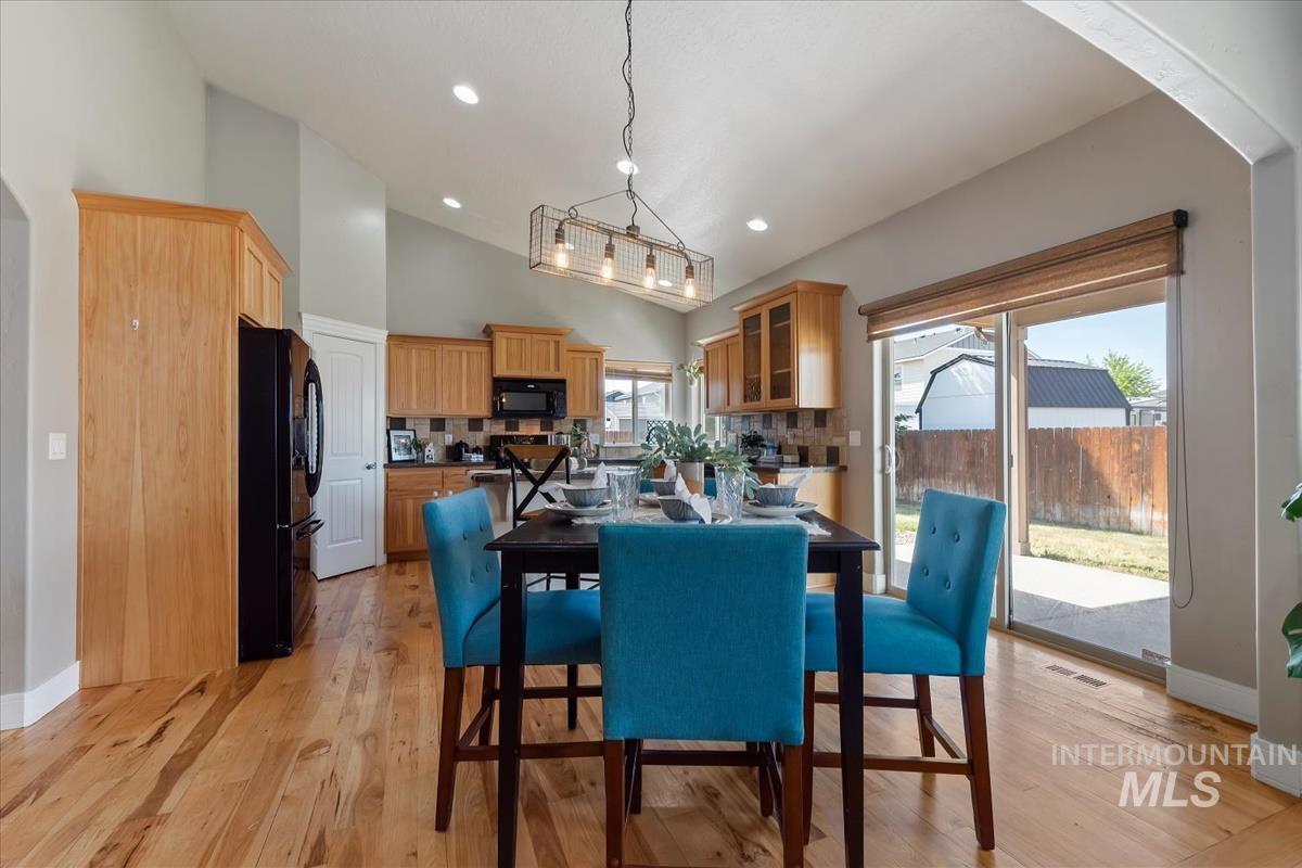 640 Southwest Miner Street Mountain Home, ID 83647 - Photo 29 of 35 Open-concept living space featuring wood-finish flooring, vaulted ceilings, and a contemporary linear chandelier