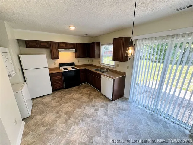 a view of a kitchen with a sink and a refrigerator