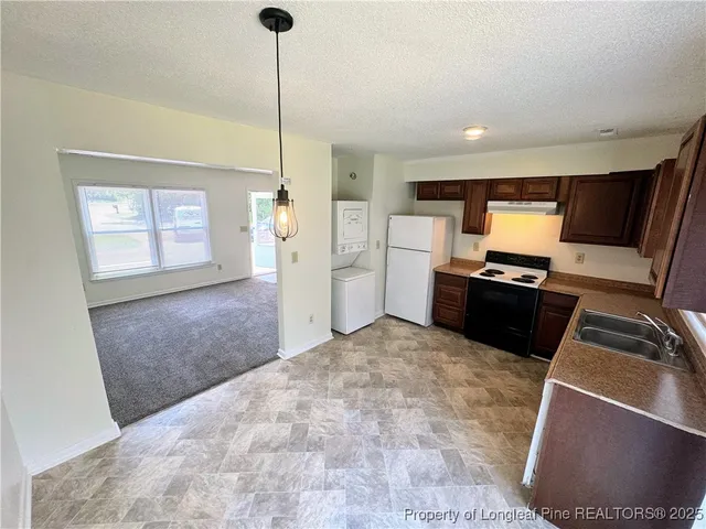 a kitchen with stainless steel appliances granite countertop a refrigerator and a stove top oven