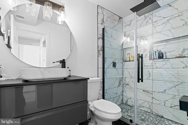 a bathroom with a sink a toilet and shower