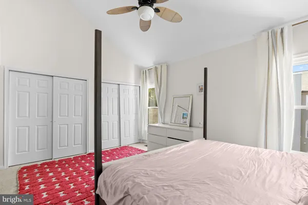 a bedroom with a bed chandelier and a window