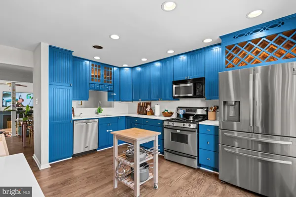 a kitchen with granite countertop stainless steel appliances a sink and a refrigerator