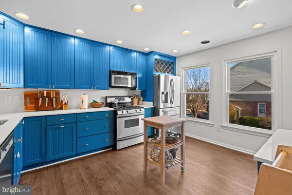 a kitchen with granite countertop wooden floors and wooden cabinets