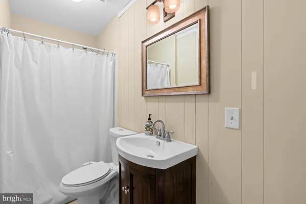 a bathroom with a sink toilet and mirror