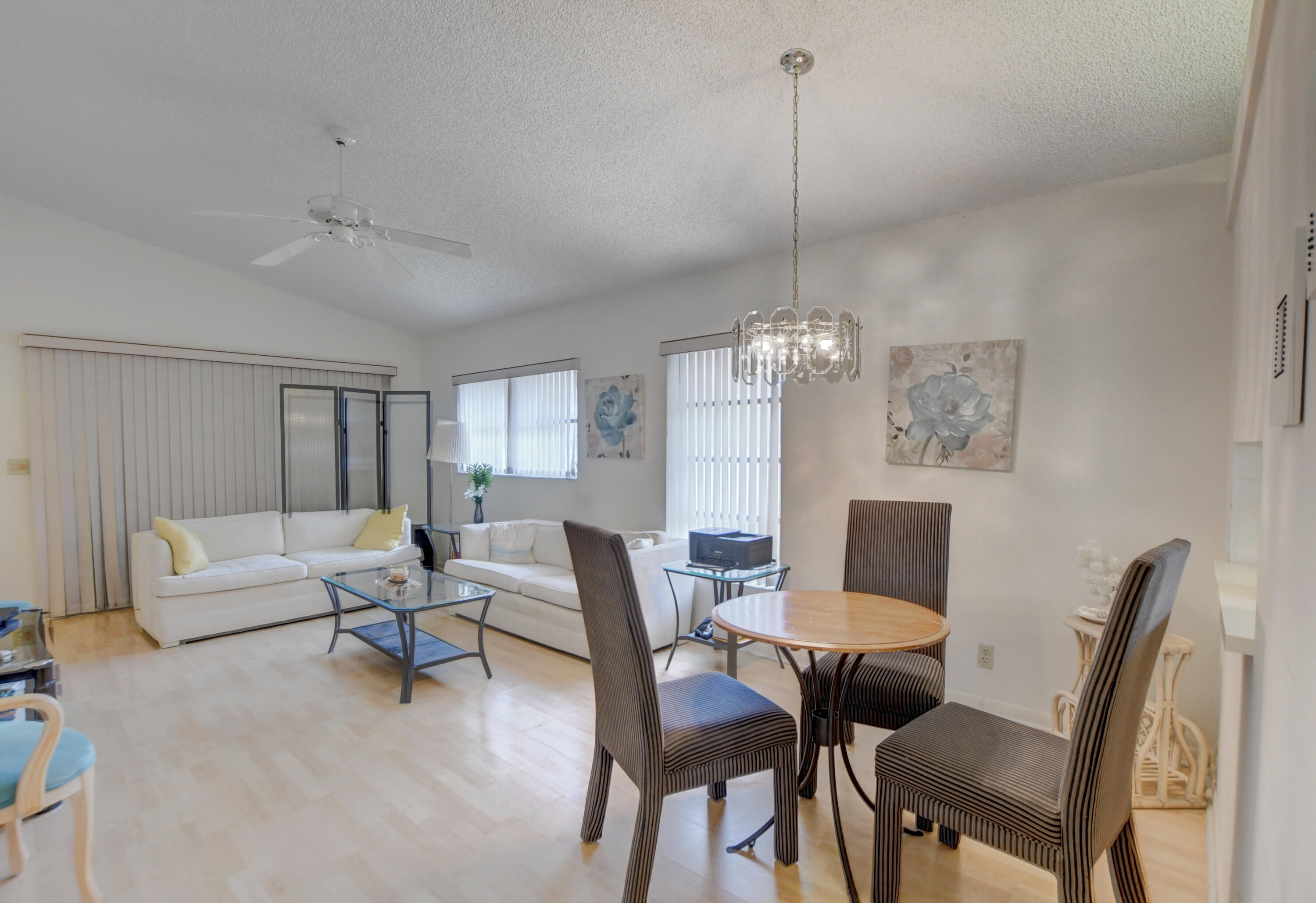 8089 Springtree Road Boca Raton, FL 33496 - Photo 14 of 44 a view of a dining room with furniture wooden floor and a chandelier