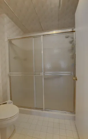 a view of a hallway with bathroom and shower