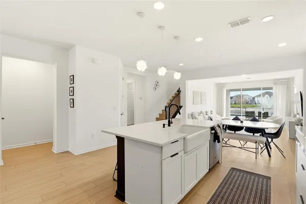 a kitchen with a sink and chairs