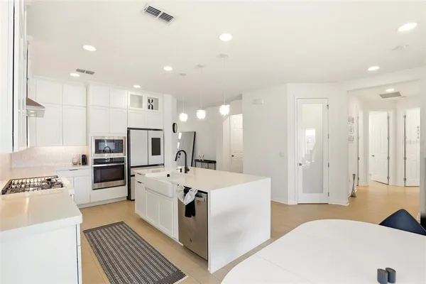 a living room with stainless steel appliances kitchen island granite countertop furniture and wooden floor